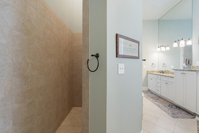 bathroom featuring a tile shower, vanity, and tile patterned floors