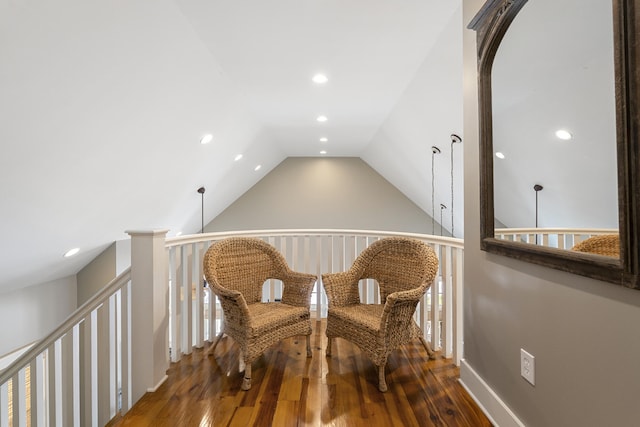 sitting room with vaulted ceiling and dark wood-type flooring