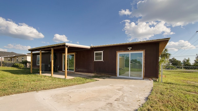 rear view of house featuring a yard and a patio area