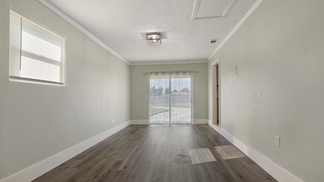 empty room featuring a textured ceiling, ornamental molding, and dark wood-type flooring