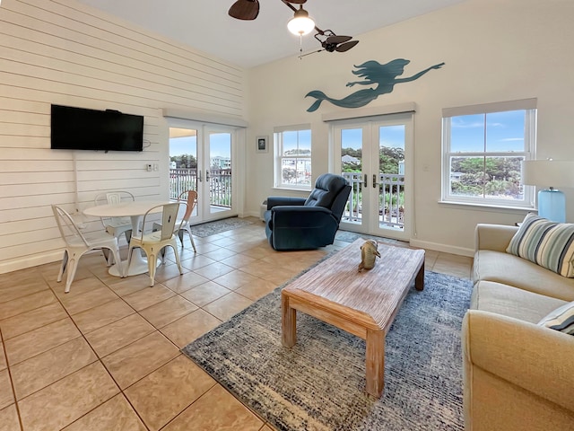 living room with french doors, high vaulted ceiling, light tile patterned flooring, and plenty of natural light