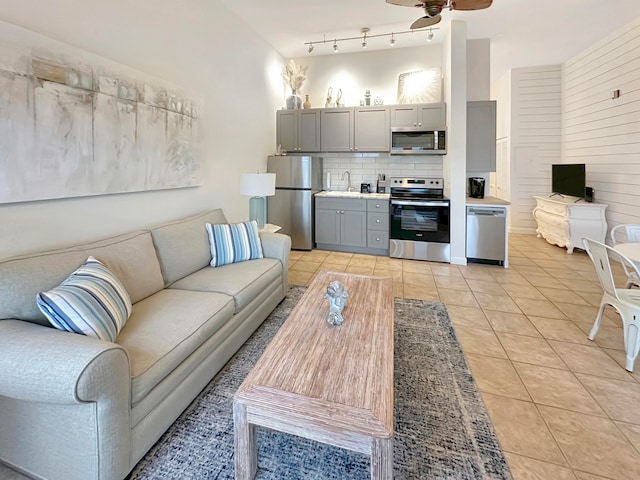 tiled living room featuring sink and ceiling fan