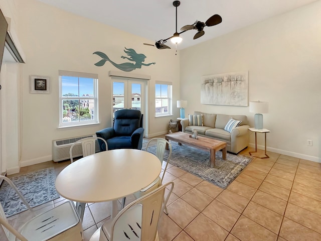 tiled living room featuring a high ceiling, a wall mounted AC, plenty of natural light, and ceiling fan