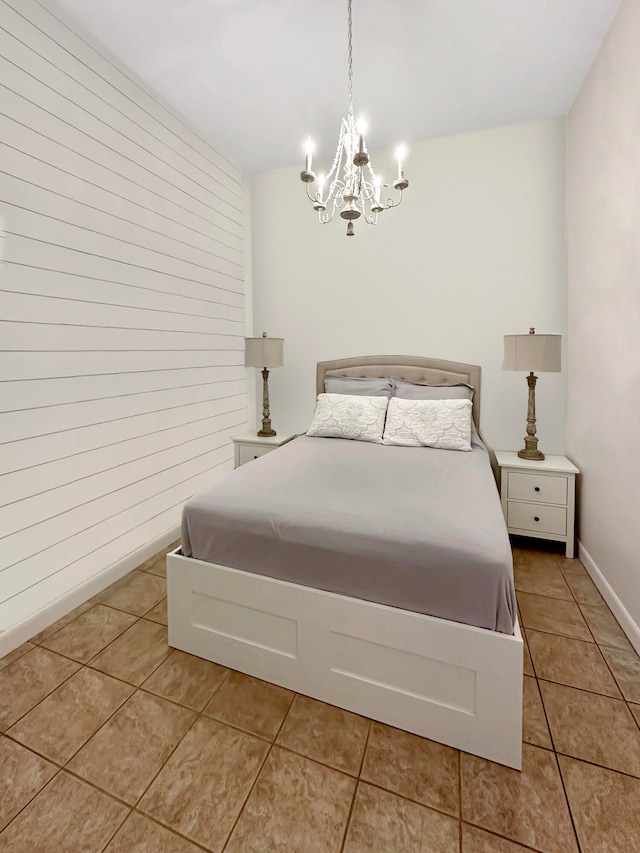 bedroom with an inviting chandelier and light tile patterned floors