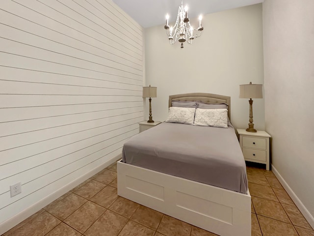 bedroom with a notable chandelier and light tile patterned floors