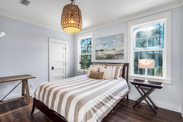 bedroom featuring crown molding and dark hardwood / wood-style floors