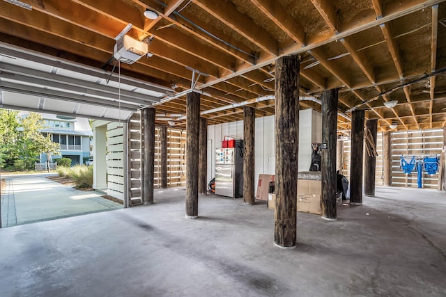 garage with a garage door opener and stainless steel refrigerator