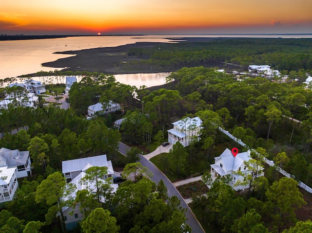 aerial view at dusk featuring a water view