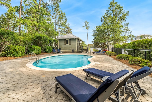 view of swimming pool featuring a patio and an outdoor structure