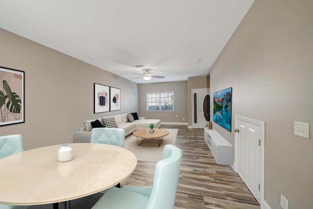 dining space featuring baseboards, a ceiling fan, and wood finished floors