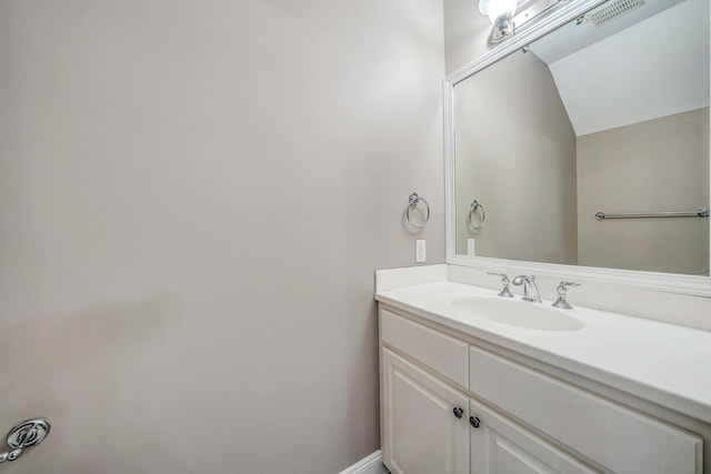 bathroom featuring vaulted ceiling, visible vents, and vanity