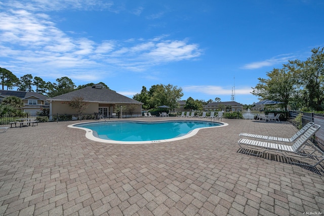 pool with a patio and fence