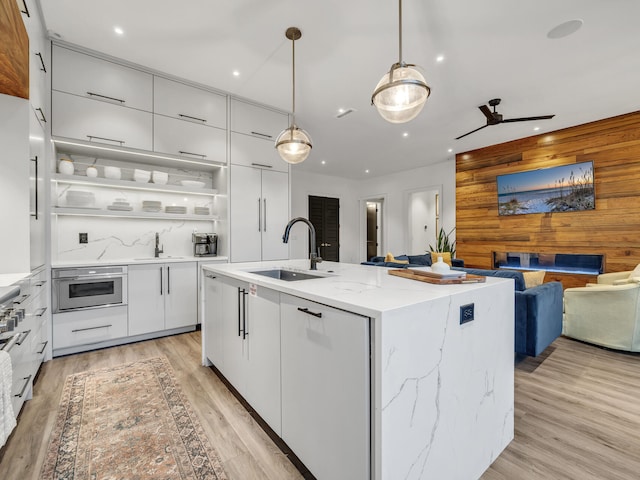 220 N Saint Francis Dr, Miramar Beach, FL 32550 - kitchen with modern cabinets, recessed lighting, white cabinetry, light wood-style flooring, and a center island with sink