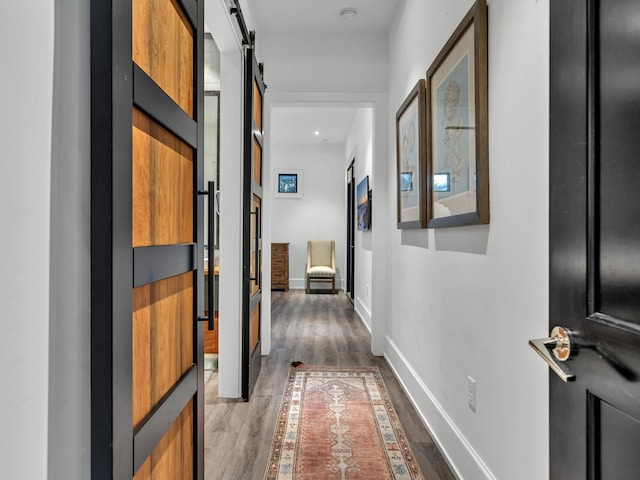 hallway with hardwood / wood-style flooring and a barn door