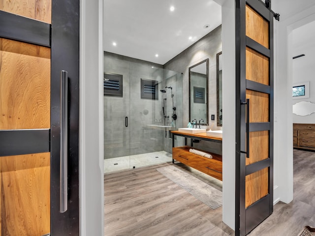 bathroom with walk in shower, hardwood / wood-style flooring, and vanity