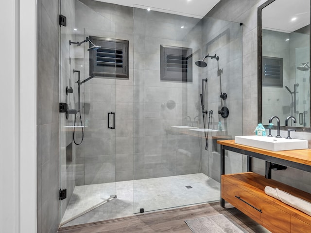 bathroom featuring a shower with shower door, vanity, and hardwood / wood-style flooring