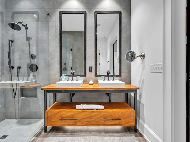 bathroom featuring a tile shower, wood-type flooring, and vanity