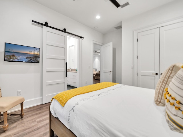 220 N Saint Francis Dr, Miramar Beach, FL 32550 - bedroom with light wood-style floors, a barn door, recessed lighting, a closet, and ensuite bath