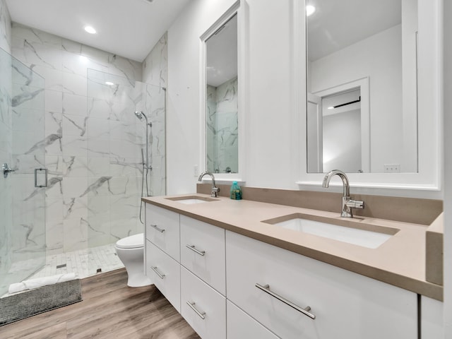 bathroom featuring wood-type flooring, vanity, walk in shower, and toilet