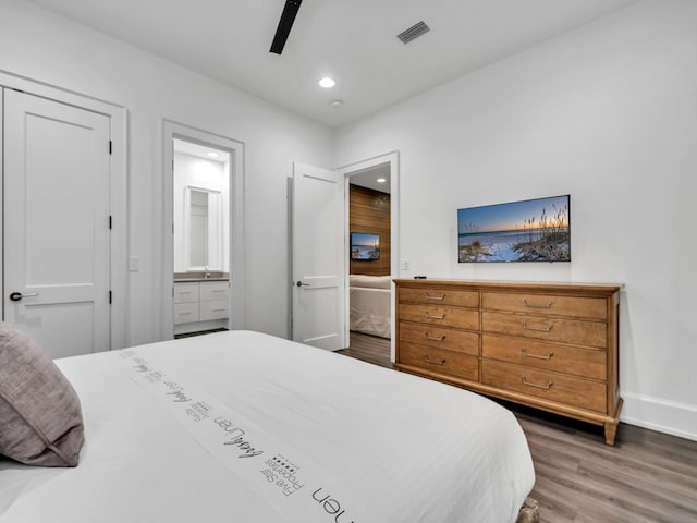 bedroom with ensuite bath, ceiling fan, and dark wood-type flooring