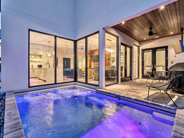 view of swimming pool featuring ceiling fan and a patio