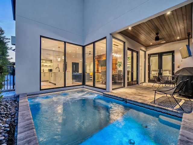 pool at dusk featuring a patio