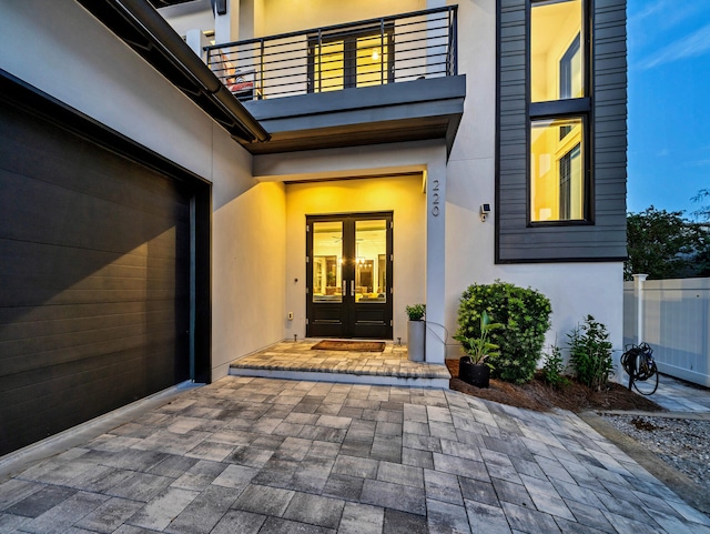 entrance to property with french doors, a balcony, and a patio