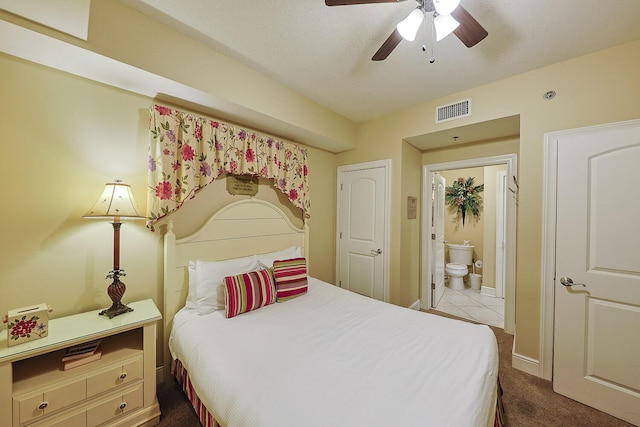 bedroom with ceiling fan, carpet floors, and ensuite bath