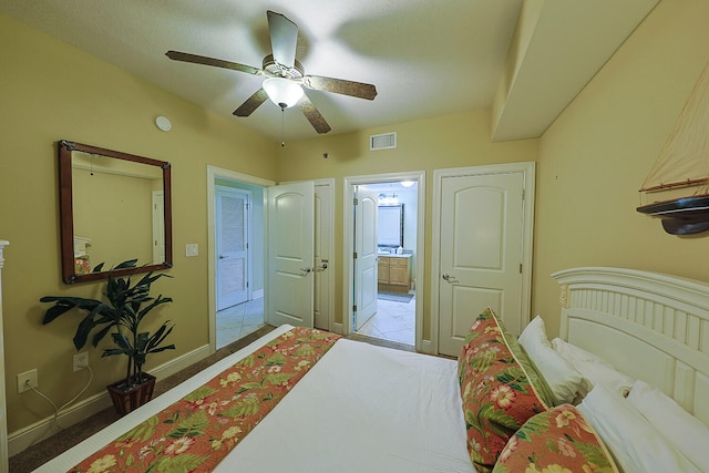 tiled bedroom with ensuite bath and ceiling fan