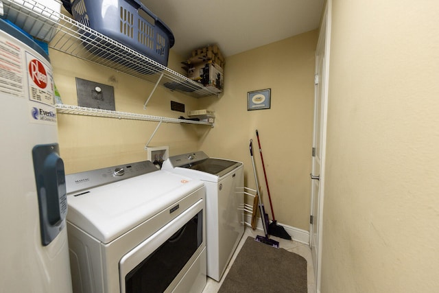 clothes washing area featuring water heater and washer and dryer