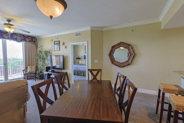 dining space with crown molding, carpet floors, and a textured ceiling