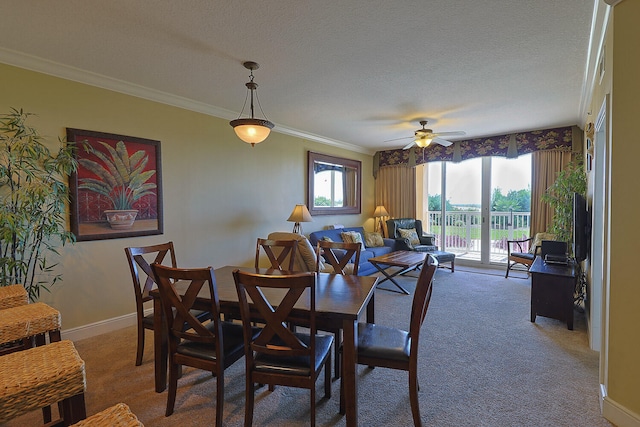 dining room featuring dark carpet, ornamental molding, a textured ceiling, and ceiling fan