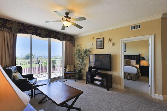 living room with ceiling fan, crown molding, a textured ceiling, and carpet floors