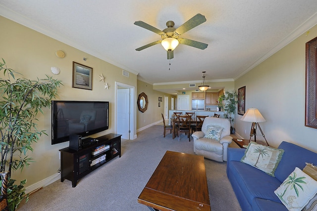 living room with ornamental molding, light carpet, and ceiling fan