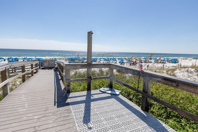 wooden terrace with a water view and a view of the beach