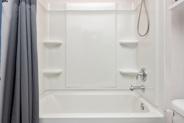 bathroom featuring shower / tub combo with curtain and toilet