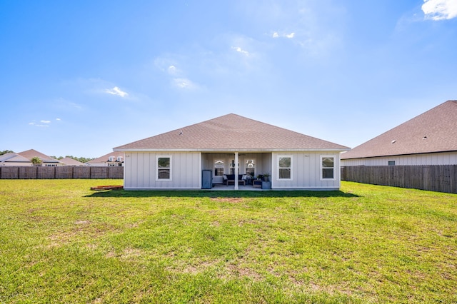 rear view of property featuring a lawn and a patio