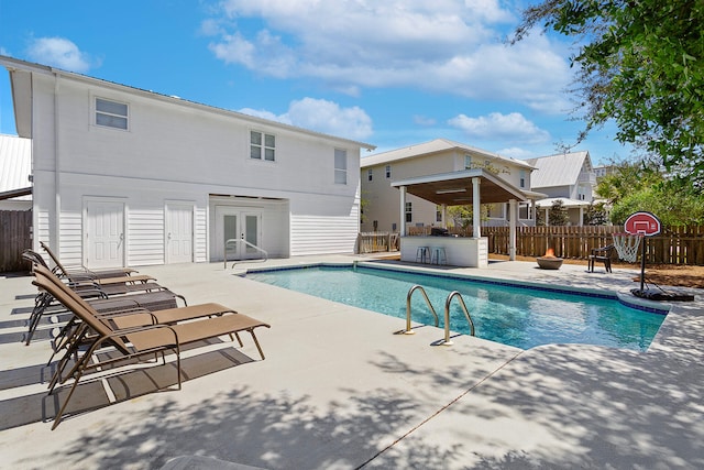 view of swimming pool featuring french doors and a patio