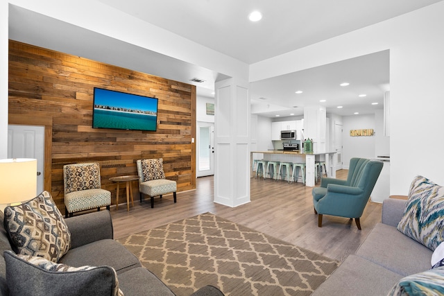 living room featuring wooden walls and hardwood / wood-style flooring