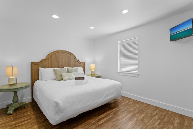 bedroom with dark hardwood / wood-style flooring