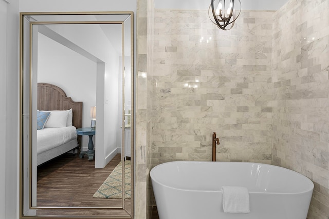 bathroom featuring wood-type flooring, a bath, and tile walls