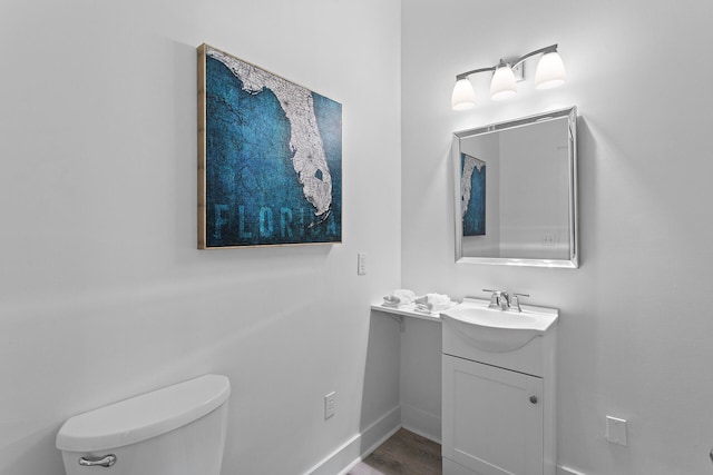 bathroom with vanity, toilet, and hardwood / wood-style flooring