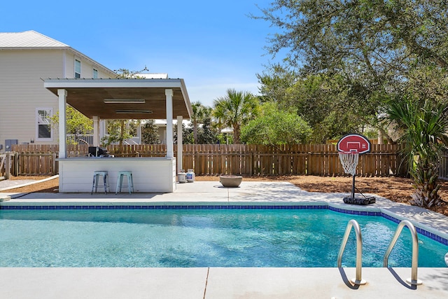 view of swimming pool featuring exterior bar and a patio area