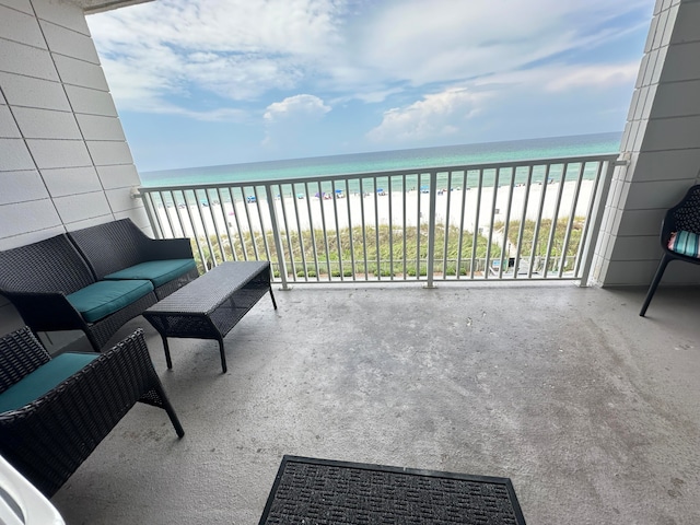 balcony featuring a water view and a beach view