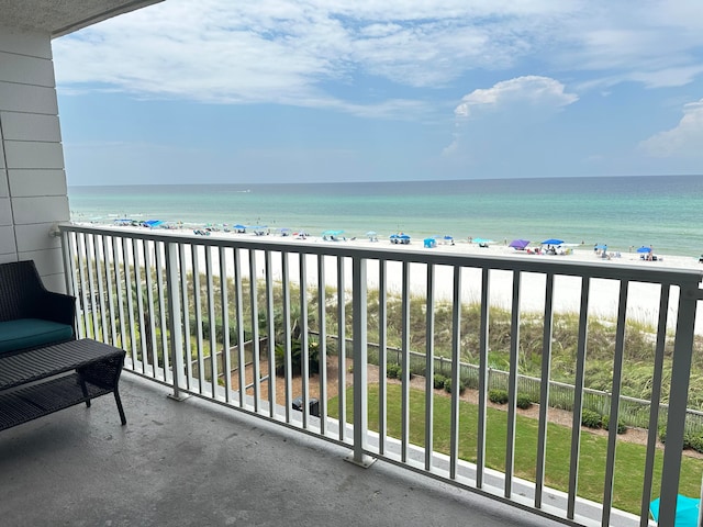 balcony featuring a view of the beach and a water view