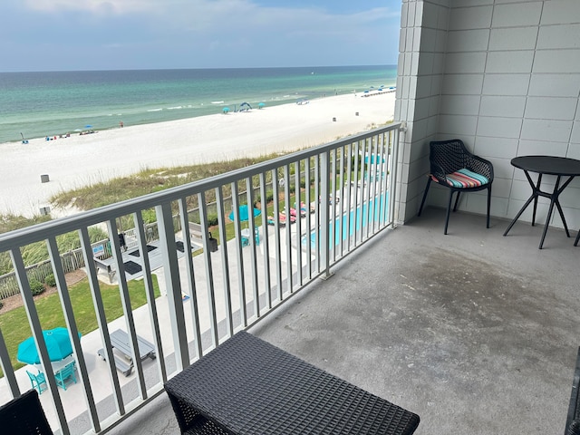 balcony featuring a water view and a beach view