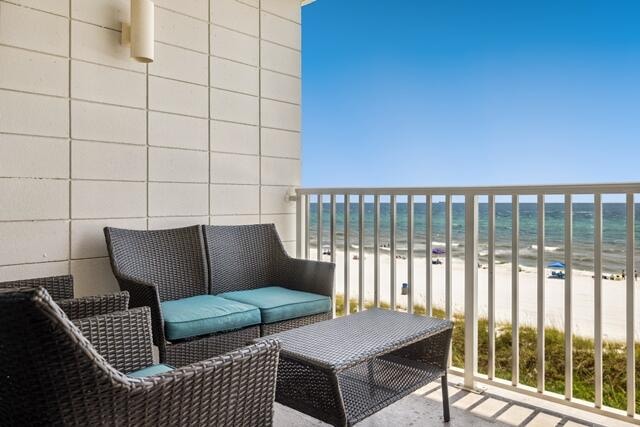 balcony with a beach view and a water view