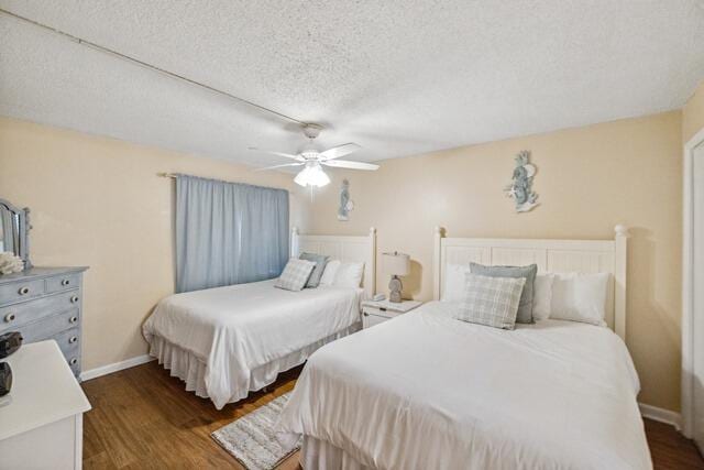 bedroom featuring a textured ceiling, ceiling fan, and dark hardwood / wood-style flooring