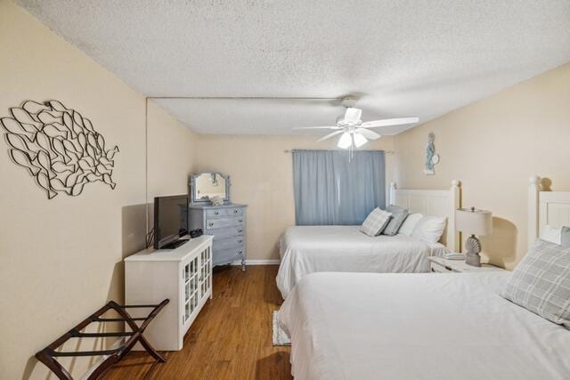 bedroom with a textured ceiling, dark hardwood / wood-style floors, and ceiling fan