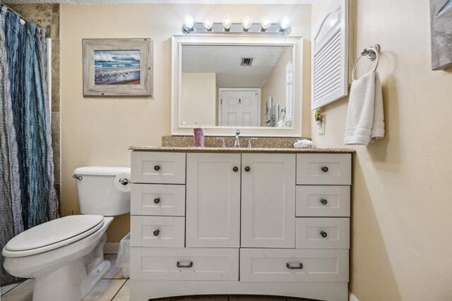 bathroom with vanity, toilet, and tile patterned floors